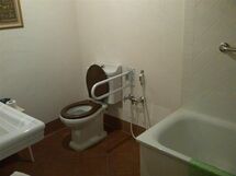 Generous spaces around the WC, a small shower and a solid metal handle next to it, make the bathroom easy to use for people with disabilities