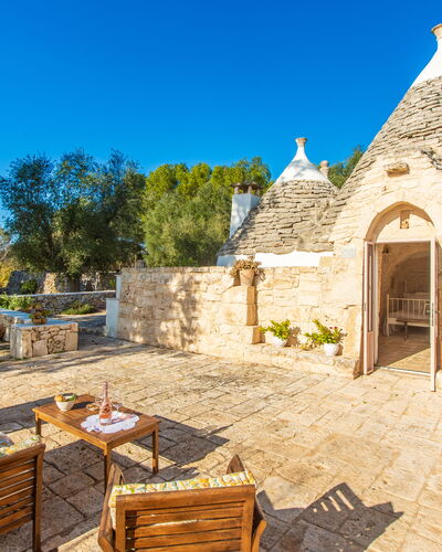 Trullo Con Piscina Per Bambini: Sky, Plant, Furniture, Property, Building, Table, Tree, Chair, Outdoor Furniture, Cottage
