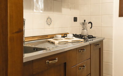 Appartamento Ontani: Kitchen, Countertop, Kitchen Appliance, Cabinetry, Wood, Flooring, Major Appliance, Interior Design, Stove, Kitchen Stove